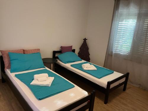 Dos camas en una habitación con sábanas azules y blancas. en APPARTMENT LANA, en Izola
