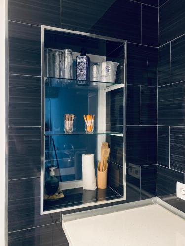a blue tiled bathroom with a shelf above a sink at Apartamento Delfin - Punta Umbria in Punta Umbría