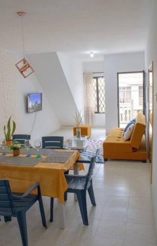 a living room with a table and chairs and a couch at Apartamento con buena ubicación PARA FAMILIA Grande in Cali