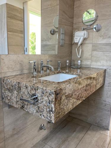 bagno con grande lavandino in marmo e specchio di Kira Panzió a Lengyeltóti