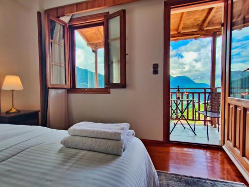 a bedroom with a bed and a window with a view at Majestic Vista Residence in Metsovo