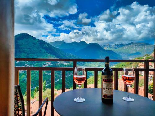 a bottle of wine sitting on a table with two glasses at Majestic Vista Residence in Metsovo