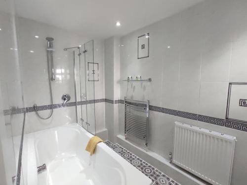 a white bathroom with a tub and a shower at Fox hill view in Parkstone