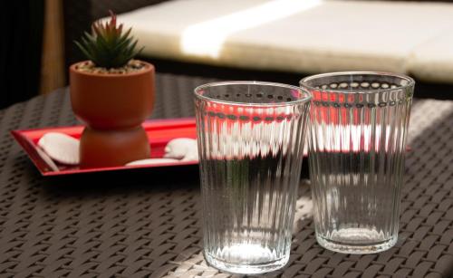 卡塔尼亞的住宿－Mirage Place B&B，两只清澈的玻璃杯坐在桌子上,放着盆子