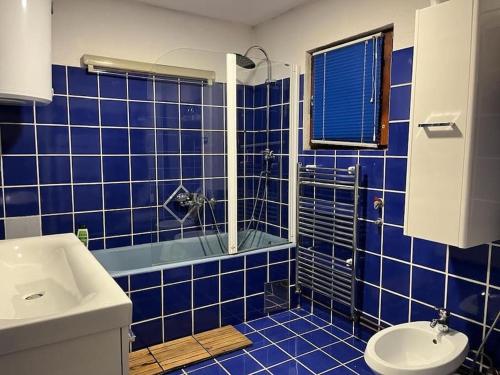 比哈奇的住宿－Villa Hacienda - Holiday Home，蓝色瓷砖浴室设有水槽和卫生间