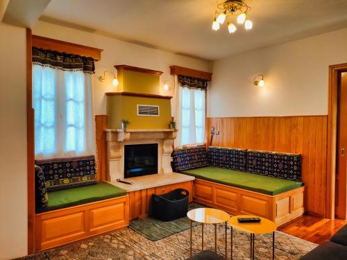 a living room with benches and a fireplace at Majestic Vista Residence in Metsovo