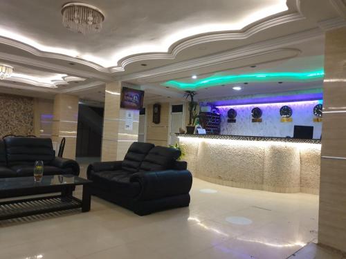 a lobby with couches and a bar with purple lights at Hôtel privilège Oran in Oran