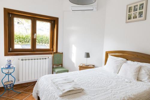 a bedroom with a white bed and a window at Quinta do Retiro in Felgar