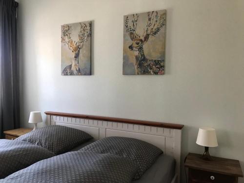 een slaapkamer met twee bedden en drie schilderijen aan de muur bij Ferienwohnung in Schmargendorf bei Angermünde in Angermünde