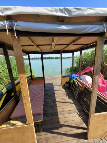 a boat with a roof on a wooden deck at Domek Drewniany w Dolinie Symsarny in Lidzbark Warmiński
