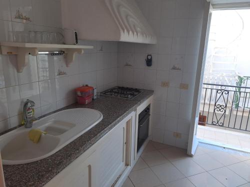 a kitchen with a sink and a stove at DreamHouse Ischia-Lacco Ameno in pieno centro a soli 70 metri dal mare! in Ischia