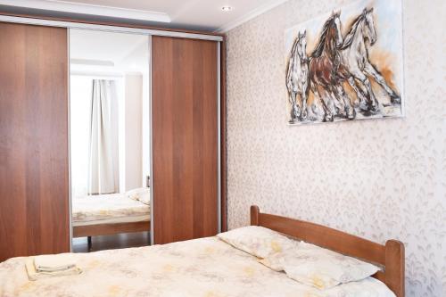 a bedroom with a bed and a painting of a horse on the wall at Апартаменти на Сихові 3й in Lviv