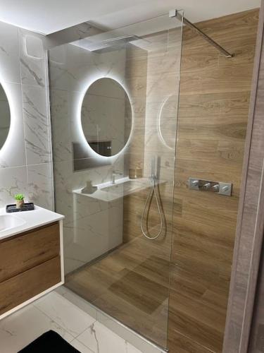 une salle de bain avec une douche avec un lavabo et un miroir dans l'établissement Appartement Lahoucine, à Boulogne-sur-Mer