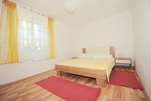 a bedroom with a bed and a red rug at Apartment Karla in Jadrtovac