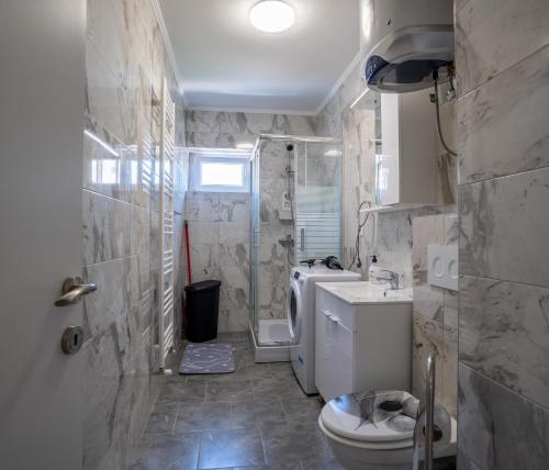 a bathroom with a toilet and a shower and a sink at Apartman Josip in Gospić