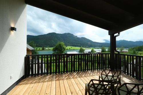ヴァイセンゼーにあるSee Hotel Kärntnerhof- das Seehotel am Weissensee!の湖の景色を望むバルコニー(椅子付)
