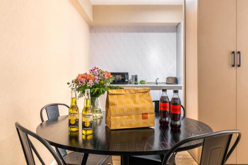 a dining room table with bottles and flowers on it at Trendy Apartment in Puerto Madero in Buenos Aires