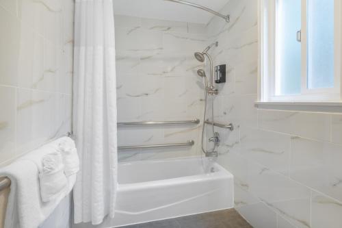 a white bathroom with a tub and a shower at Aura Inn Monterey in Monterey