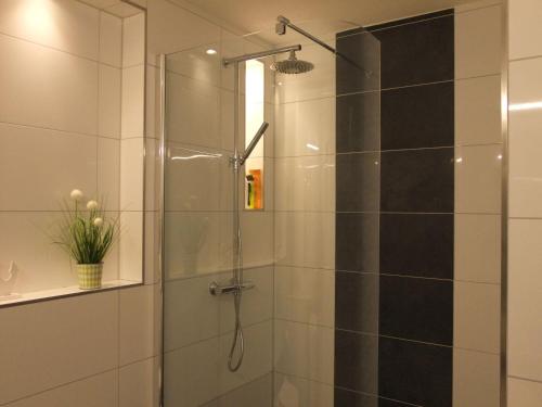 La salle de bains est pourvue d'une douche avec une porte en verre. dans l'établissement Frische-Brise-05-10, à Cuxhaven