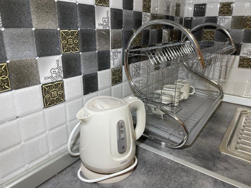 a kitchen counter with a mixer and a drying rack at Bora Apartmani - FREE PARKING - CITY CENTER in Vranje