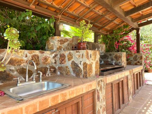 une cuisine extérieure avec un évier et un mur en pierre dans l'établissement Tierra Mia Hacienda Ruta del Vino, à Valle de Guadalupe