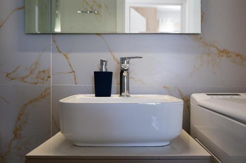 a bathroom with a sink and a mirror and a toilet at Aerino in Chania