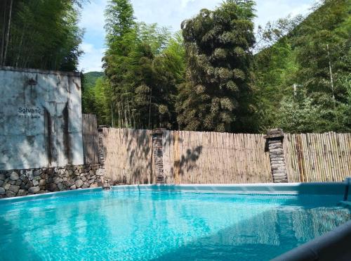 a swimming pool in front of a wooden fence at Moganshan Solvang Village Boutique Hotel in Deqing