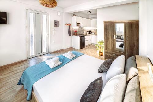 duże białe łóżko w pokoju z kanapą w obiekcie Holiday House Heraklion & Roof Garden w Heraklionie
