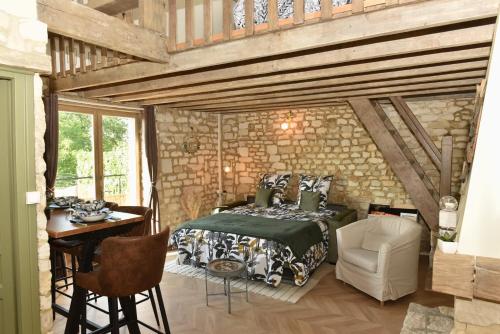 1 dormitorio con 1 cama, mesa y sillas en Maisonnette du bonheur - Vue campagne - Baignoire Balnéo 32 jets - Lits Queen size en Vadencourt-et-Bohéries
