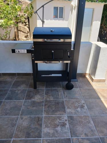 a grill sitting on a tiled floor in a backyard at Casa Azul Mountain Retreat in Vega de San Mateo