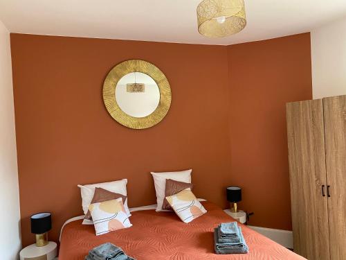 una camera da letto con un letto con uno specchio sul muro di Maison les 3 fées , 3 chambres, Chamerolles a Courcy-aux-Loges