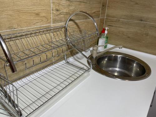 a bathroom sink with a metal basket on the wall at Bora Apartmani - FREE PARKING - CITY CENTER in Vranje