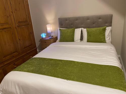 Foots CrayにあるCozy Private Room in a Beautiful Accommodation close to Orpingtonのベッドルーム1室(大型ベッド1台、緑のシーツ、枕付)
