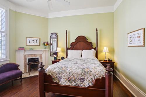 a bedroom with a large bed and a fireplace at Maison Perrier Bed & Breakfast in New Orleans