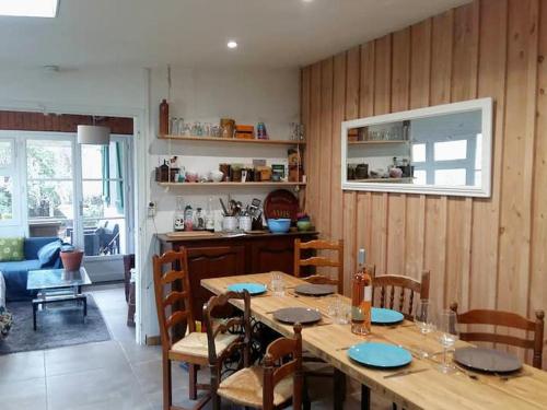 une salle à manger avec une table et des chaises ainsi qu'une cuisine dans l'établissement guesthouse bassin d'arcachon à la hume, à Gujan-Mestras