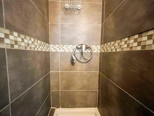 a bathroom with a shower with a tiled wall at Suite Nairobi in Villeurbanne