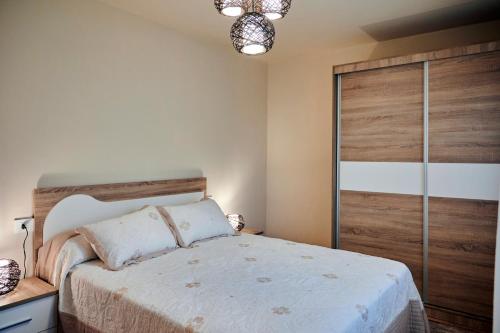 a bedroom with a large bed with a wooden door at Casa Costal in Mondariz