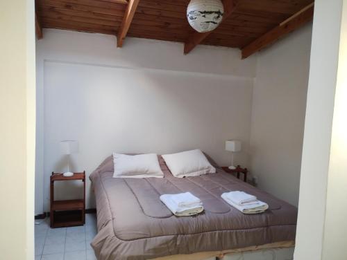 a bedroom with a bed with two towels on it at Casa Centro Bariloche in San Carlos de Bariloche