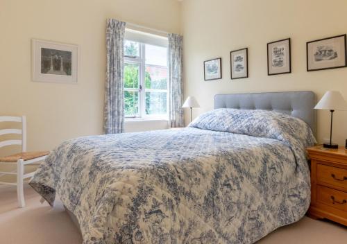 a bedroom with a bed and a window at Old Rectory Cottage in Orford