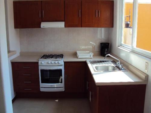 a kitchen with a stove and a sink at VILLAS RIBERA DEL PACIFICO in Ixtapa