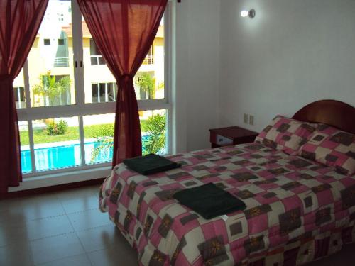 a bedroom with a bed and a large window at VILLAS RIBERA DEL PACIFICO in Ixtapa