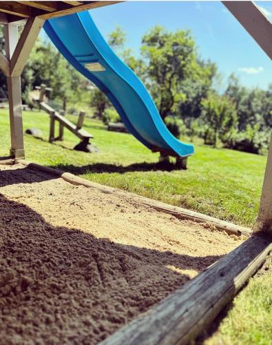 a blue slide in a park with a field at Siedlisko pod Tatrami - agroturystyka in Maruszyna
