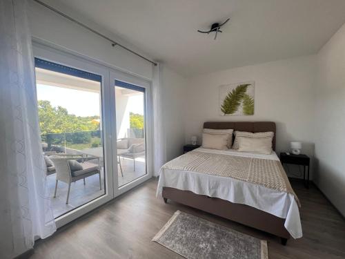 1 dormitorio con cama y ventana grande en Villa H, en Labin