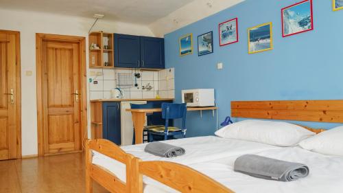 a bedroom with a bed and a blue wall at Apartment Jursport in Závažná Poruba