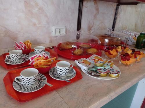 a kitchen counter with plates and cups and food on it at Villa Alfea CAMERE in Porto Cesareo