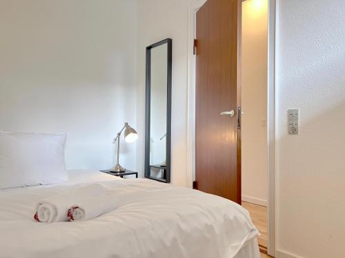 a bedroom with a white bed and a mirror at One Bedroom Apartment In Valby, Langagervej 66, in Copenhagen