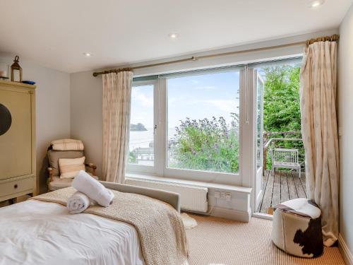 1 dormitorio con cama y ventana grande en Dolphins Reach, en Saint Mawes