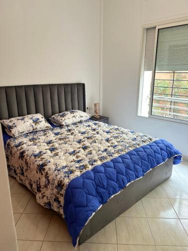 uma cama com um edredão azul num quarto em Appartement luxueux à Agdal près de la gare em Rabat