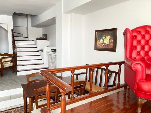 a living room with a red chair and a staircase at Anamar Symi Residences in Symi