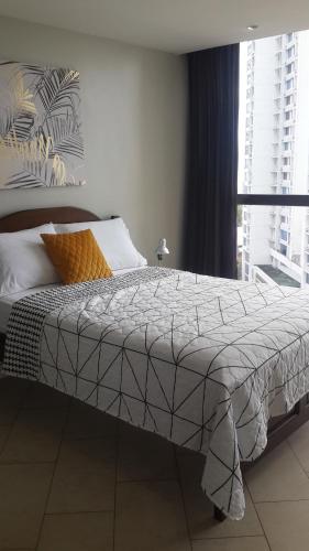 a bed in a bedroom with a large window at Room at the Sky in Panama City